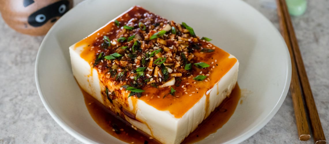 Spicy cold tofu in a bowl with chopsticks