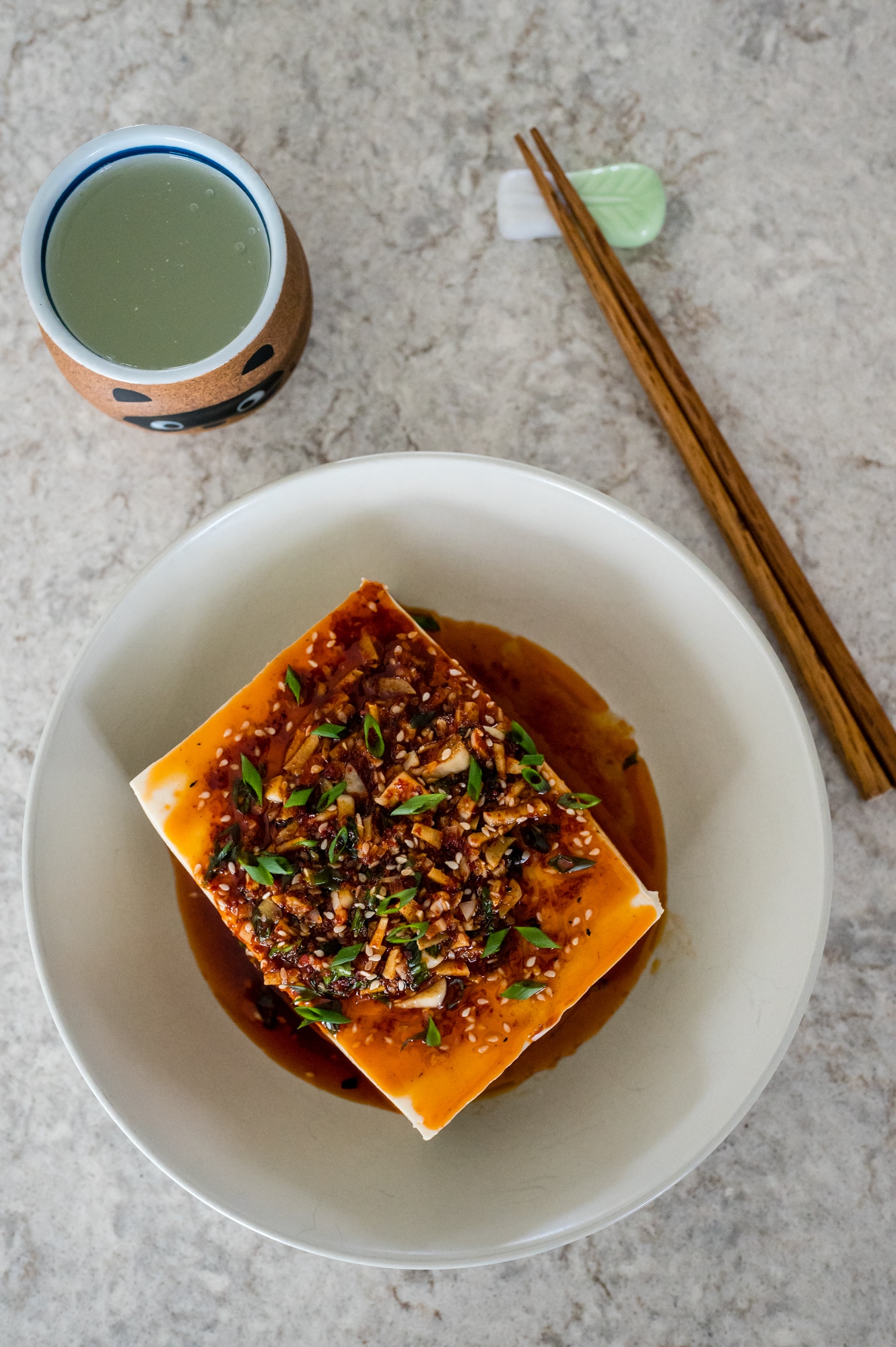 Spicy cold tofu in a bowl with chopsticks