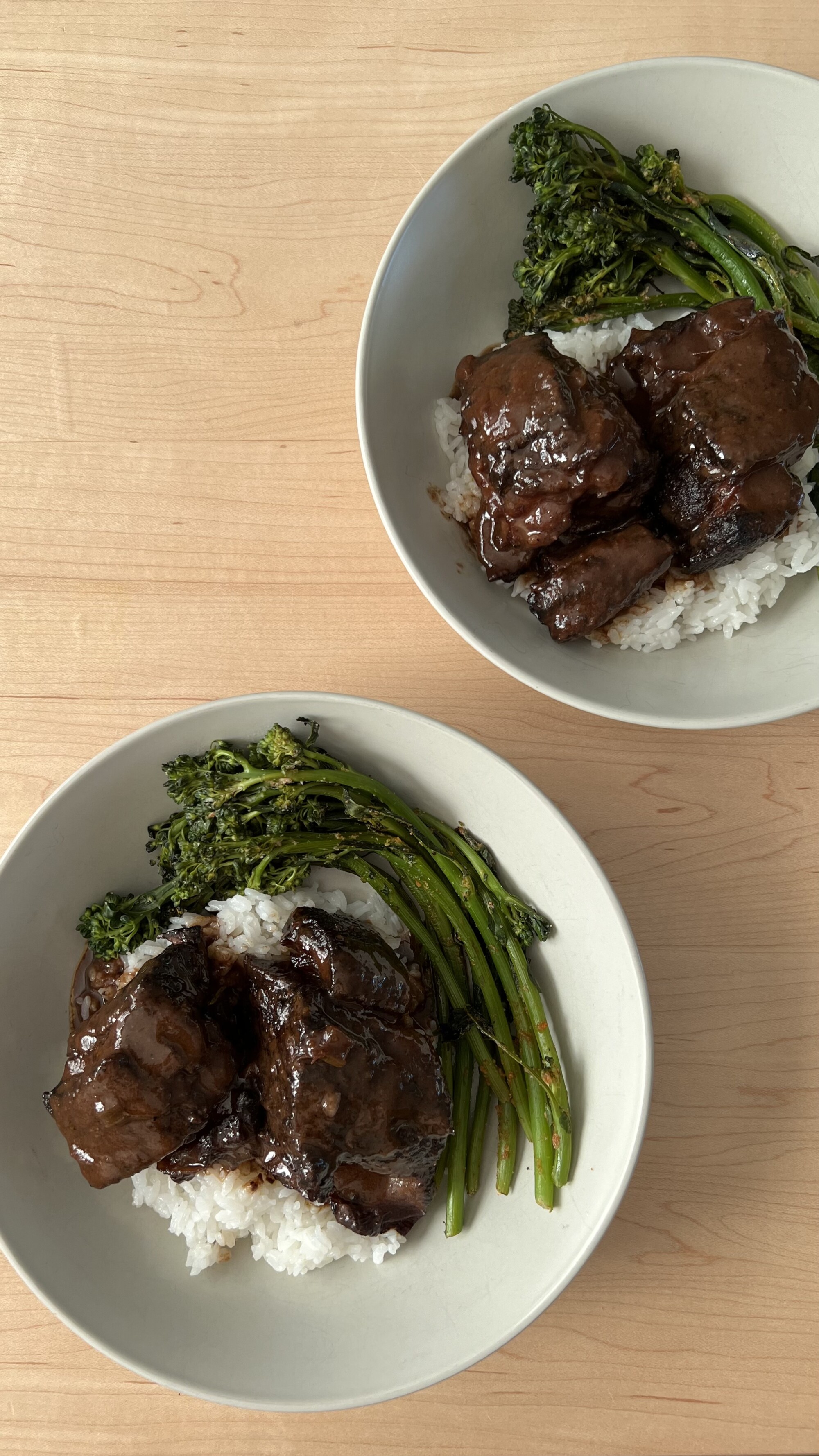 short rib on a plate with mashed potatoes and broccolini